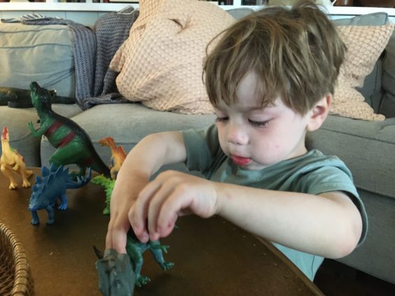 Myron playing with dinosaur figures